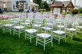 Summer outdoor wedding ceremony decoration. White classic chairs to accommodate guests at the ceremony. Ball gypsophila decoration Royalty Free Stock Photo