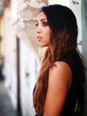 Summer outfit - African Italian woman, dressed with black and bronze dress, waiting. Royalty Free Stock Photo