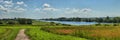 Summer panorama with a river and a wooden path Royalty Free Stock Photo