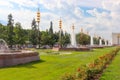 Summer park with fountains and large lanterns. A green lawn with beautiful flowers.