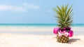 Summer in the party.  Hipster Pineapple Fashion in sunglass and listen music on the sand beach beautiful blue sky background. Royalty Free Stock Photo