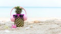Summer in the party. Hipster Pineapple Fashion in sunglass and listen music with sunblock and sandal on the sand beach Royalty Free Stock Photo