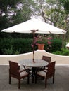 Summer patio with tables and wooden chairs under umbrella Royalty Free Stock Photo