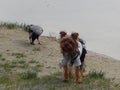 a pet dog and a bird of the gray crow stand on the shore of the lake