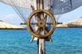 Wooden ship steering wheel and fishing net on the blue sea and sky background