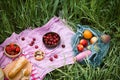 Summer picnic on the with cherries in the wooden coconut bowls, fresh bread and glass bottle of juice