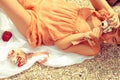 Summer picnic concept. Portrait of a happy young woman lying at the seaside in trendy dress, holding vintage photocamera and Royalty Free Stock Photo