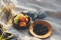 Summer picnic. Fresh fruits in wooden plates and wineglasses on blanket in sunny light in meadow