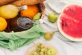 Summer picnic in the meadow on the green grass. Fruit basket, juice and bottled wine, watermelon and bread baguettes Royalty Free Stock Photo