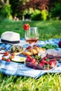 Summer picnic in the park on the grass. Wine, fruit and croissants Royalty Free Stock Photo