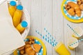 Summer picnic. Sweet picnic - orange juice and muffins, croissants and cakes on yellow and blue disposable dishes.