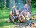 Summer picnic. Tourists hikers relaxing while having picnic snack. Picnic with friends in forest near bonfire. Hikers Royalty Free Stock Photo