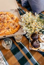 summer picnic for two. on a checkered brown plaid there is a pizza in a box, donuts with chocolate glaze Royalty Free Stock Photo