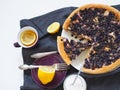 Summer pie with wild berries, nightshade and apples, covered with beaten eggs on a dark napkin on a light table.Healthy homemade Royalty Free Stock Photo