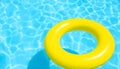 Summer Pool Fun: Bright Yellow Inflatable Ring on Blue Water Royalty Free Stock Photo