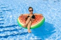 Summer pool relaxing. Young sexy woman in bikini swimsuit, sunglasses floating with inflatable rubber ring in blue water Royalty Free Stock Photo