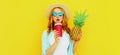 Summer portrait of attractive woman drinking juice holding pineapple wearing a straw hat, sunglasses