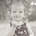 Summer portrait of beautiful baby girl. Black and white image. Kid smiling and looking at camera. Royalty Free Stock Photo
