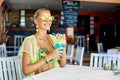 Summer portrait of a beautiful blonde woman drinking cocktail in an outdoor beach bar Royalty Free Stock Photo