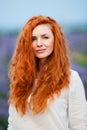 Summer portrait of a beautiful girl with long curly red hair Royalty Free Stock Photo
