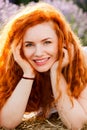 Summer portrait of a beautiful girl with long curly red hair Royalty Free Stock Photo