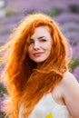 Summer portrait of a beautiful girl with long curly red hair Royalty Free Stock Photo