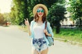 Summer portrait beautiful smiling young woman wearing a straw hat and backpack in the city park Royalty Free Stock Photo