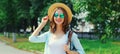 Summer portrait beautiful smiling young woman wearing a straw hat and backpack in the city park Royalty Free Stock Photo