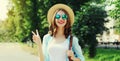 Summer portrait beautiful smiling young woman wearing a straw hat and backpack in the city park Royalty Free Stock Photo