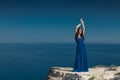 Summer portrait. Beautiful woman standing on a cliff over blue s Royalty Free Stock Photo