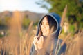 Portrait of beautiful young Asian woman enjoying nature on grass meadow at sunrise Royalty Free Stock Photo