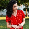 Summer portrait of a beautiful young curly girl in a red fashionable vintage dress Royalty Free Stock Photo
