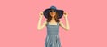 Summer portrait of beautiful young woman model wearing black round straw hat, striped dress on pink background Royalty Free Stock Photo