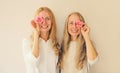 Summer portrait of caucasian happy smiling two women, middle aged mother or sister and adult daughter covering her eyes with pink Royalty Free Stock Photo