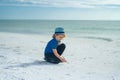 Summer portrait of childen draws on the sand. Boy drawing on sand at seaside. Child drawing sand by imaginary on beach