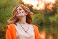 Summer portrait of a girl on a pond background. Woman with face painting on the background of the lake. Developing hair in the