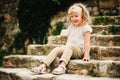 Summer portrait of happy child girl sitting on stone stairs Royalty Free Stock Photo