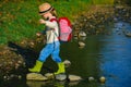 Summer portrait of happy cute child girl traveling and camp. Little girl child walking in river. Summer at countryside