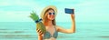 Summer portrait of happy laughing young woman taking selfie with phone with pineapple wearing straw hat, sunglasses on the beach Royalty Free Stock Photo