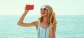 Summer portrait of happy laughing young woman taking a selfie picture by phone with papaya on a beach on sea background Royalty Free Stock Photo