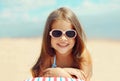 Summer portrait of happy smiling little girl child lying on sand beach Royalty Free Stock Photo