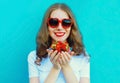 Summer portrait of happy smiling woman with handful of fresh strawberries wearing a red heart shaped sunglasses Royalty Free Stock Photo