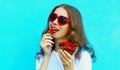 Summer portrait of happy smiling woman with handful of fresh strawberries wearing a red heart shaped sunglasses Royalty Free Stock Photo