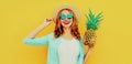 Summer portrait happy smiling woman with pineapple having fun wearing a straw hat, sunglasses over colorful yellow Royalty Free Stock Photo