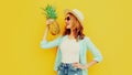 Summer portrait happy smiling woman with pineapple having fun wearing a straw hat, sunglasses over colorful yellow Royalty Free Stock Photo