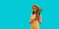 Summer portrait of happy smiling woman with pineapple wearing sunglasses, straw hat posing on blue background Royalty Free Stock Photo