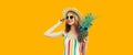 Summer portrait of happy smiling woman with pineapple wearing sunglasses, straw hat posing on yellow background Royalty Free Stock Photo