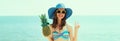 Summer portrait of happy smiling young woman on the beach with funny pineapple wearing straw hat Royalty Free Stock Photo