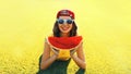 Summer portrait of happy smiling young woman eating fresh juicy slice of watermelon on the grass in the summer park Royalty Free Stock Photo