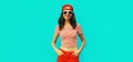 Summer portrait of happy smiling young woman model wearing baseball cap, red shorts on blue background Royalty Free Stock Photo